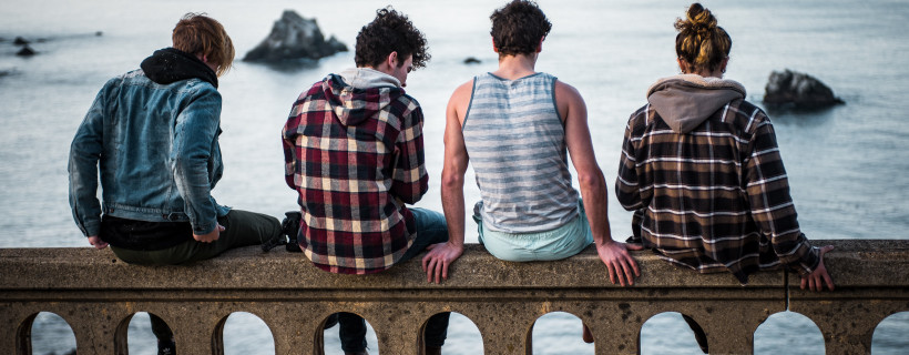 Jugendliche sitzen auf Brüstung als Symbol für Schuldnerberatung für Jugendliche