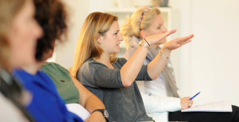 Teilnehmer*in erklärt gestikulierend eine Situation in der Weiterbildung zum Systemischen Deeskalationscoach