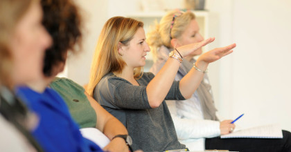 Teilnehmer*in erklärt gestikulierend eine Situation in der Weiterbildung zum Systemischen Deeskalationscoach