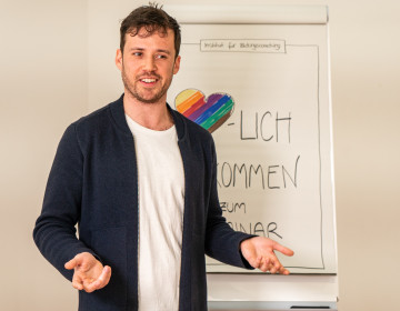 Ein Dozent erläutert Inhalte der Qualifizierung zum*zur Systemischen Kinder- und Jugendberater*in